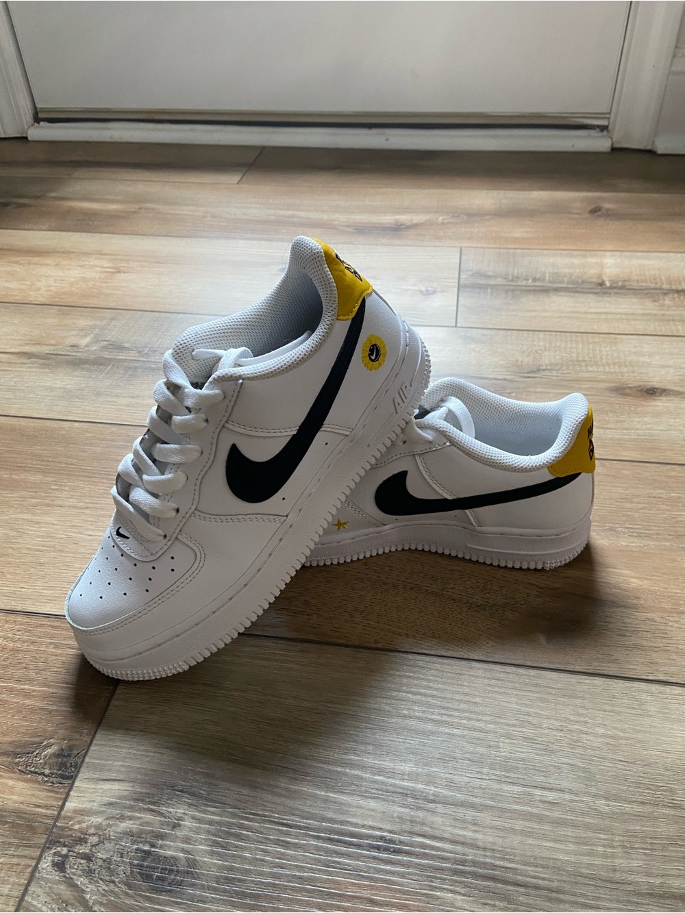 Nike White Sneakers with Black Swoosh and Yellow Heel Accents